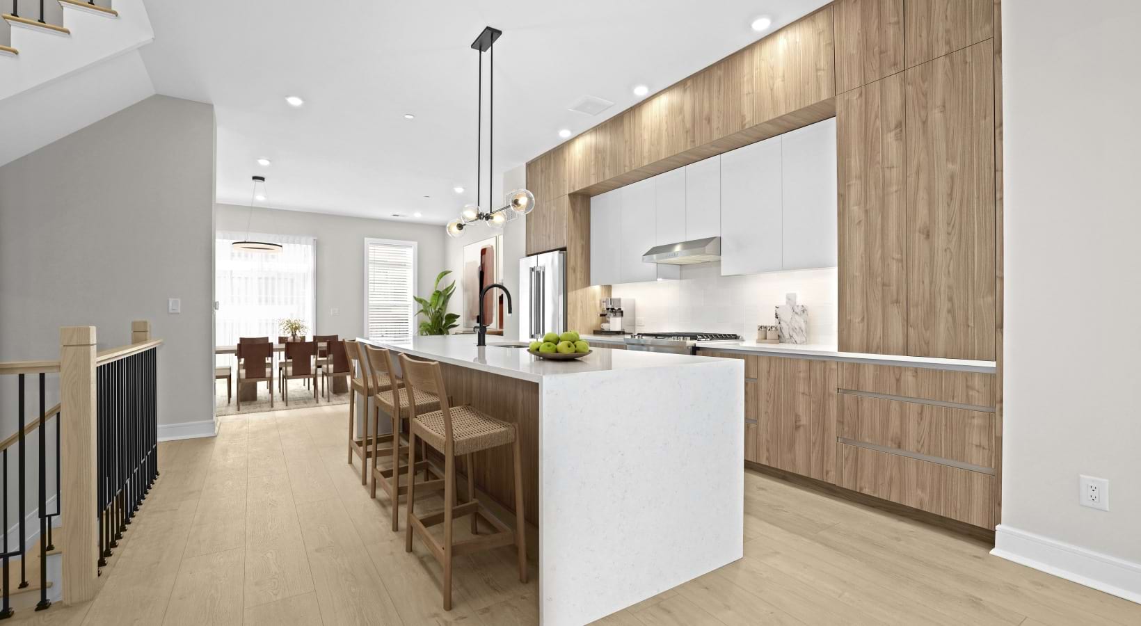 Stairs leading to the townhome kitchen with island and stools