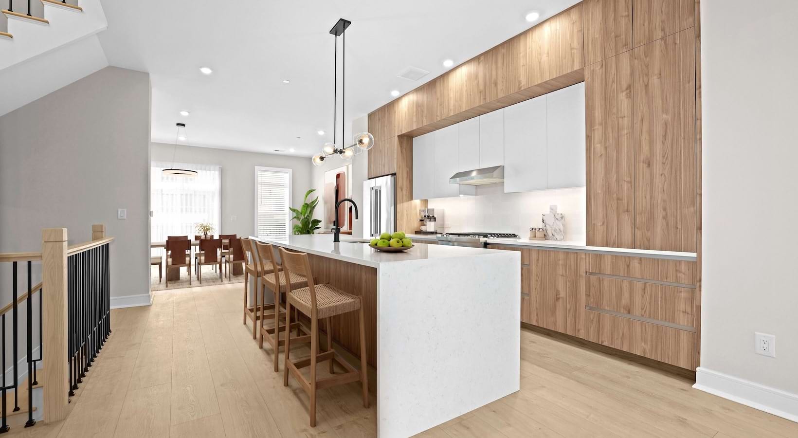Stairs leading to the townhome kitchen with island and stools