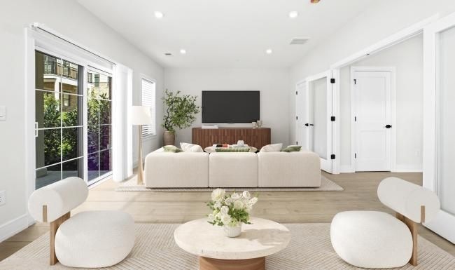 a living room with a tv, couch and chairs
