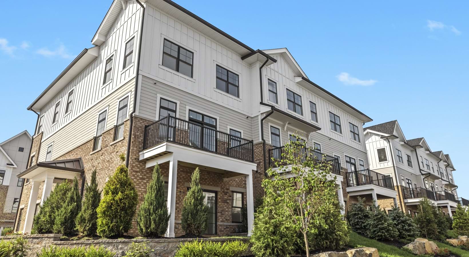 Corner image of a townhome exterior with landscaping
